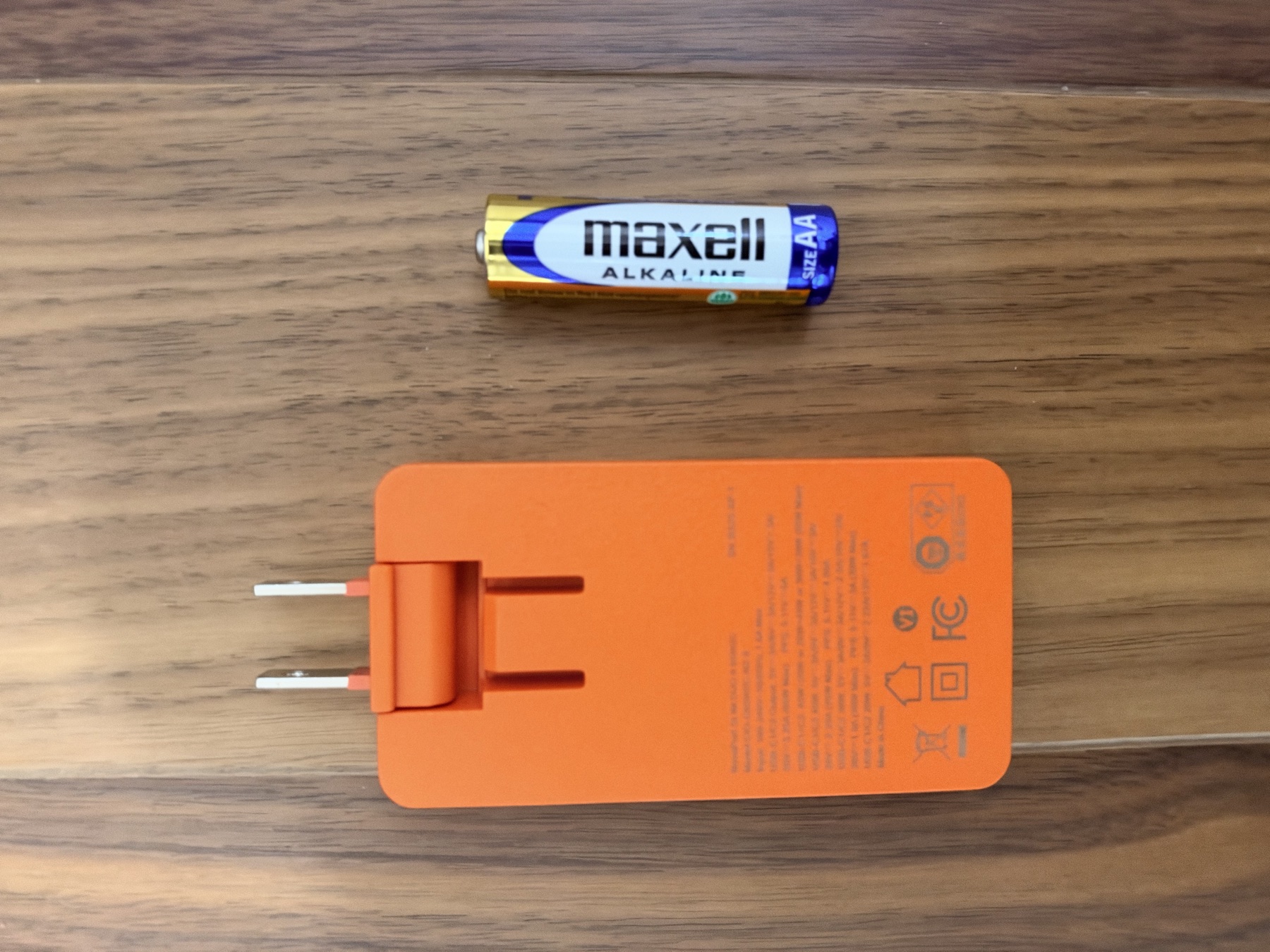 単三電池と並べたCIO NovaPort SLIM DUO II 65W2Cの背面。プラグの角度を変えた状態