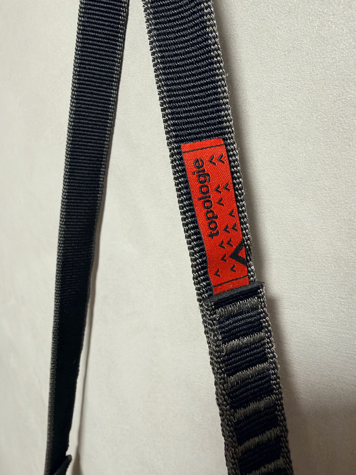 20mm Slingの黒いウェビングとTopologieのオレンジ色のタグの接写