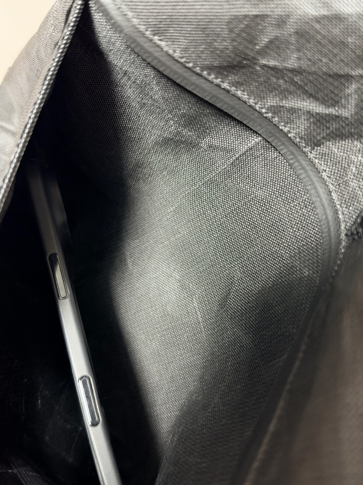 背面のファスナーポケットにスマートフォンを入れた様子