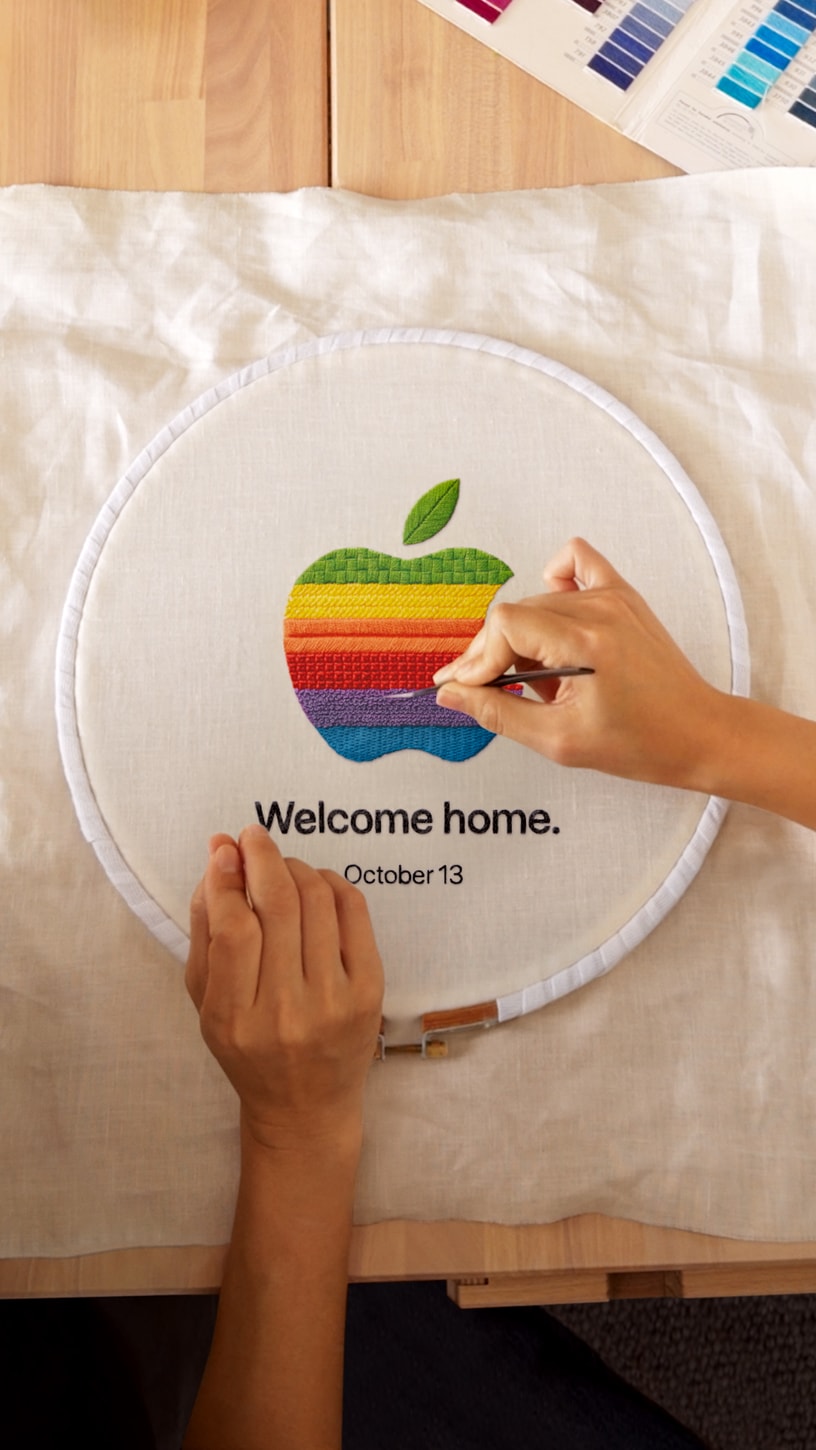 虹色のAppleロゴを刺繍し、Welcome homeとOctober 13を添えたApple公式告知画像