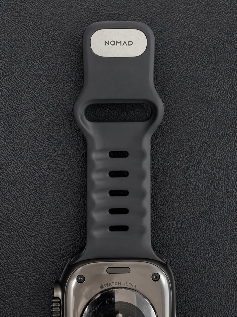 NOMADロゴ入りの金属ピンと余ったバンドを内側へ通す開口部